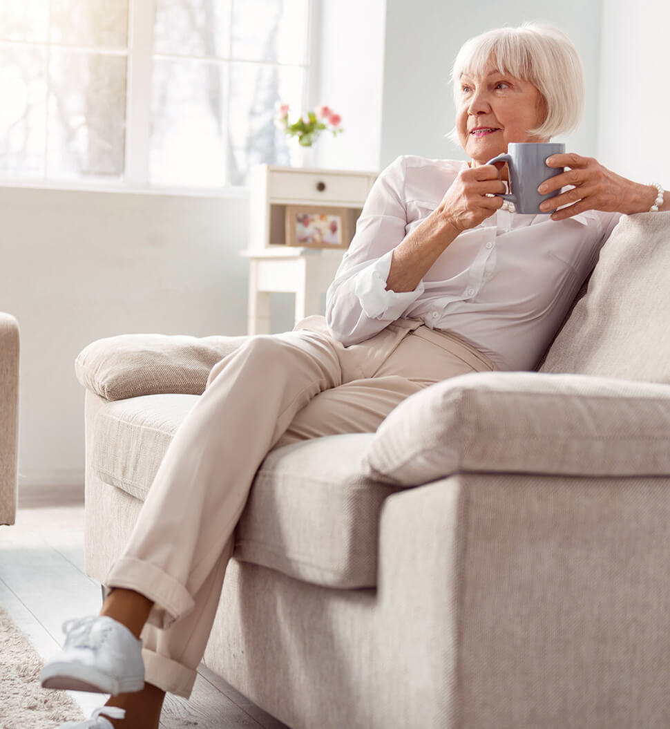 senior woman enjoying coffee on the couch