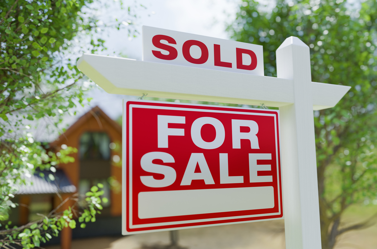 For Sale Real Estate Sign In Front of Property with "sold" on top of it
