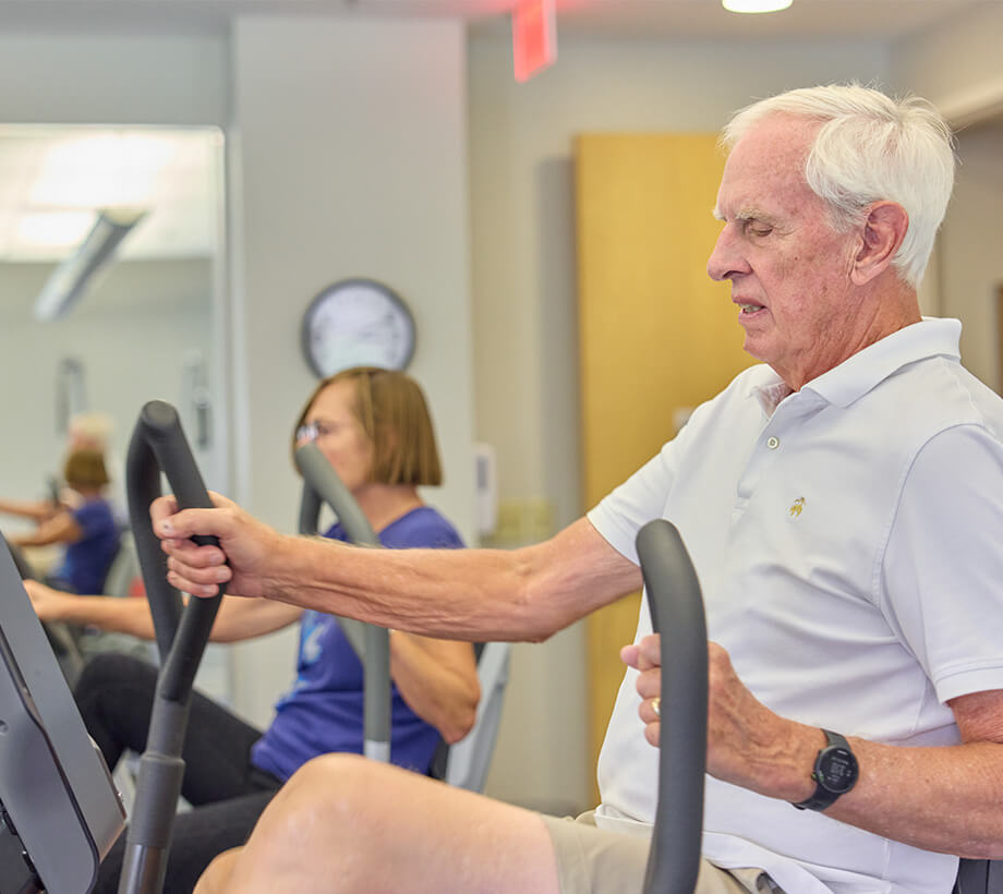 Senior residents using exercise bikes at a fitness center for active living.