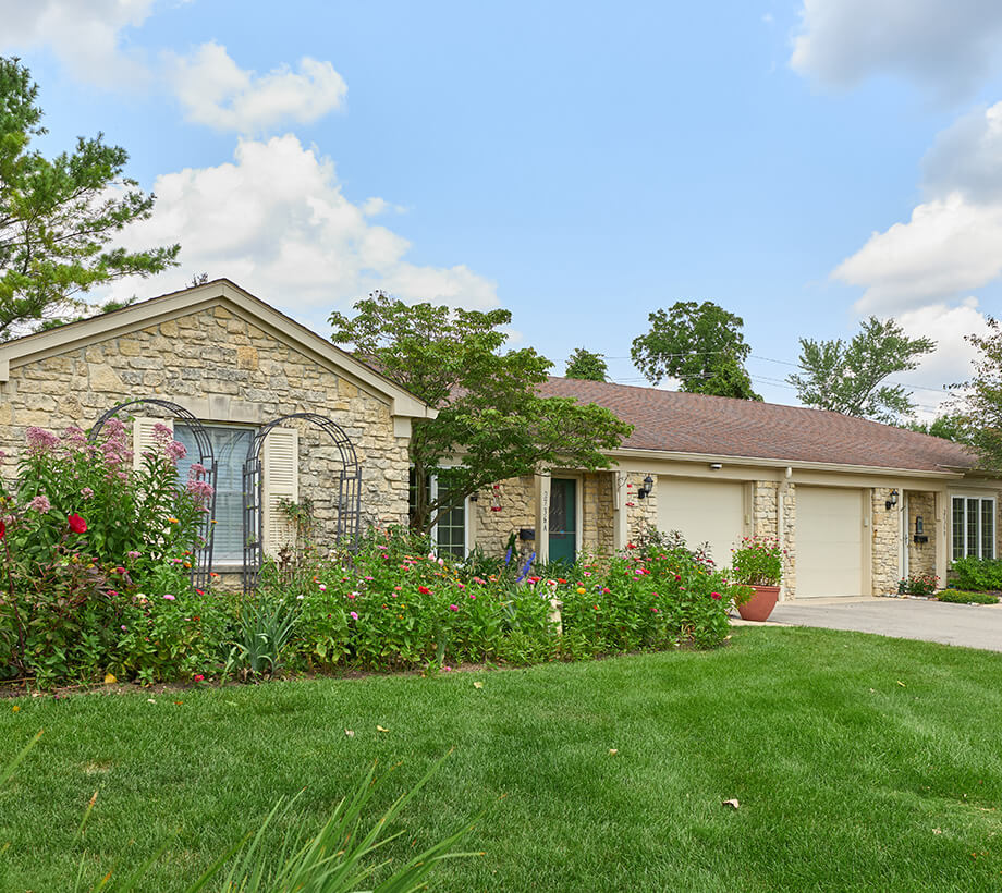 Single-story stone unit with beautiful garden in a picturesque senior community.