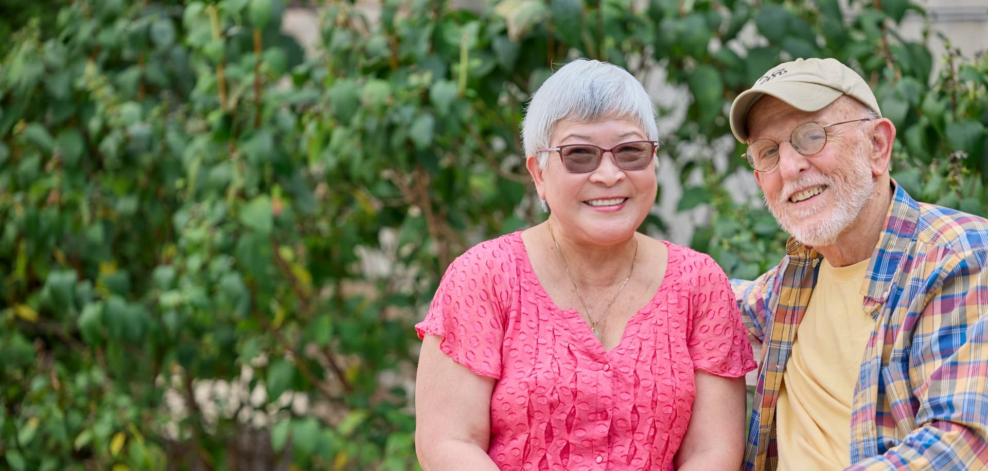 Happy senior couple smiling on a bench outdoors