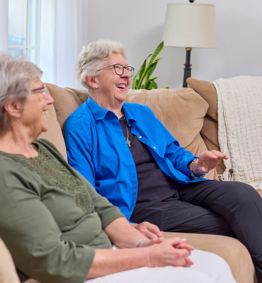 Senior friends sitting on couch laughing