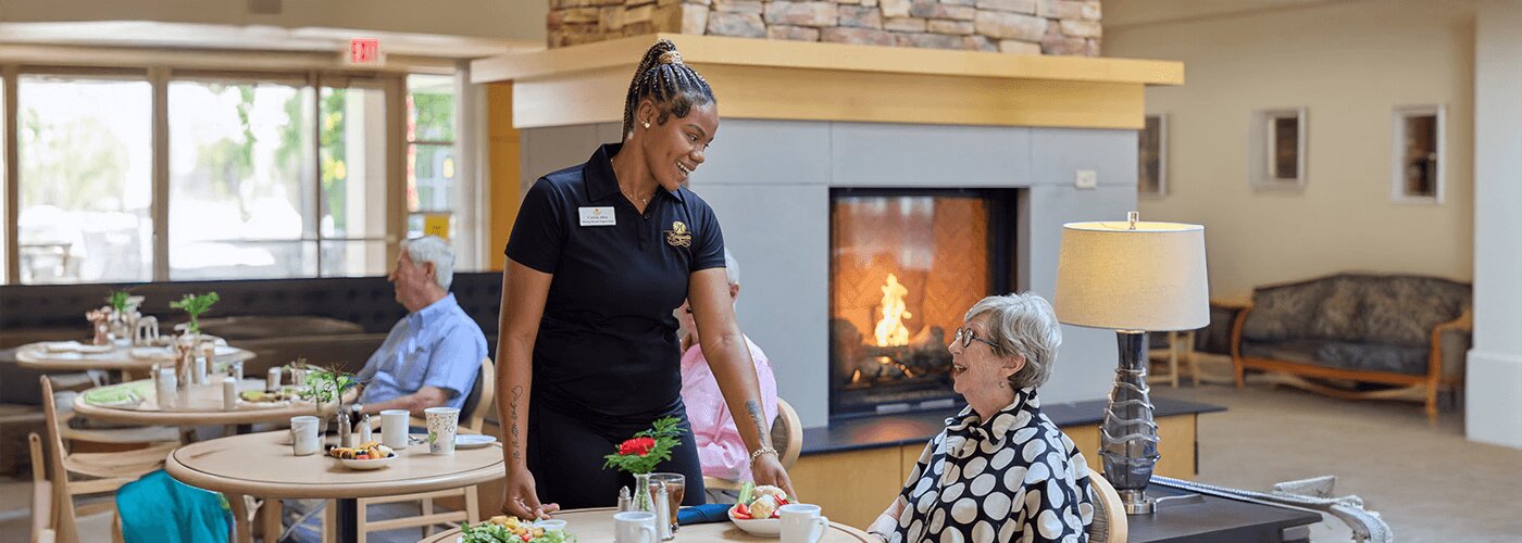 Senior woman being served a bowl of fruit