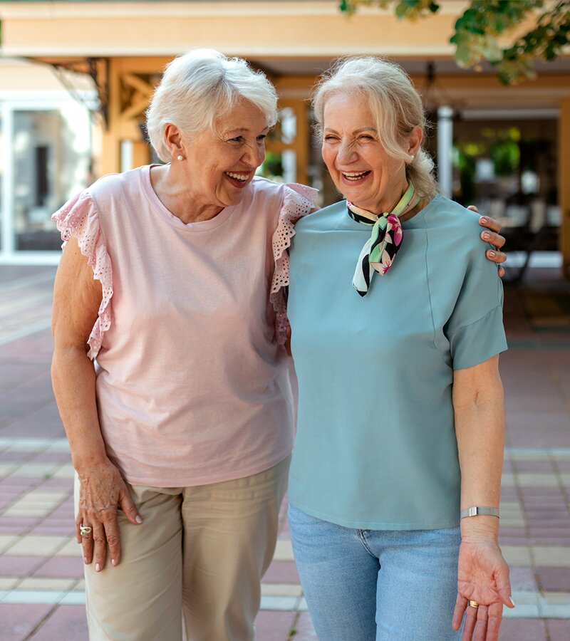 Senior women walking with their arms around them