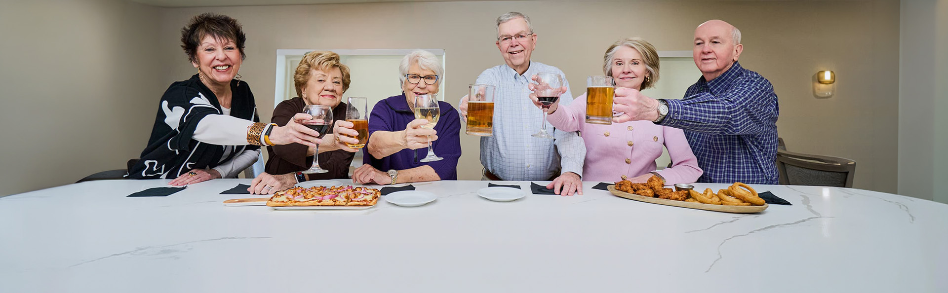 Friends raising their beer and wine glasses to toast