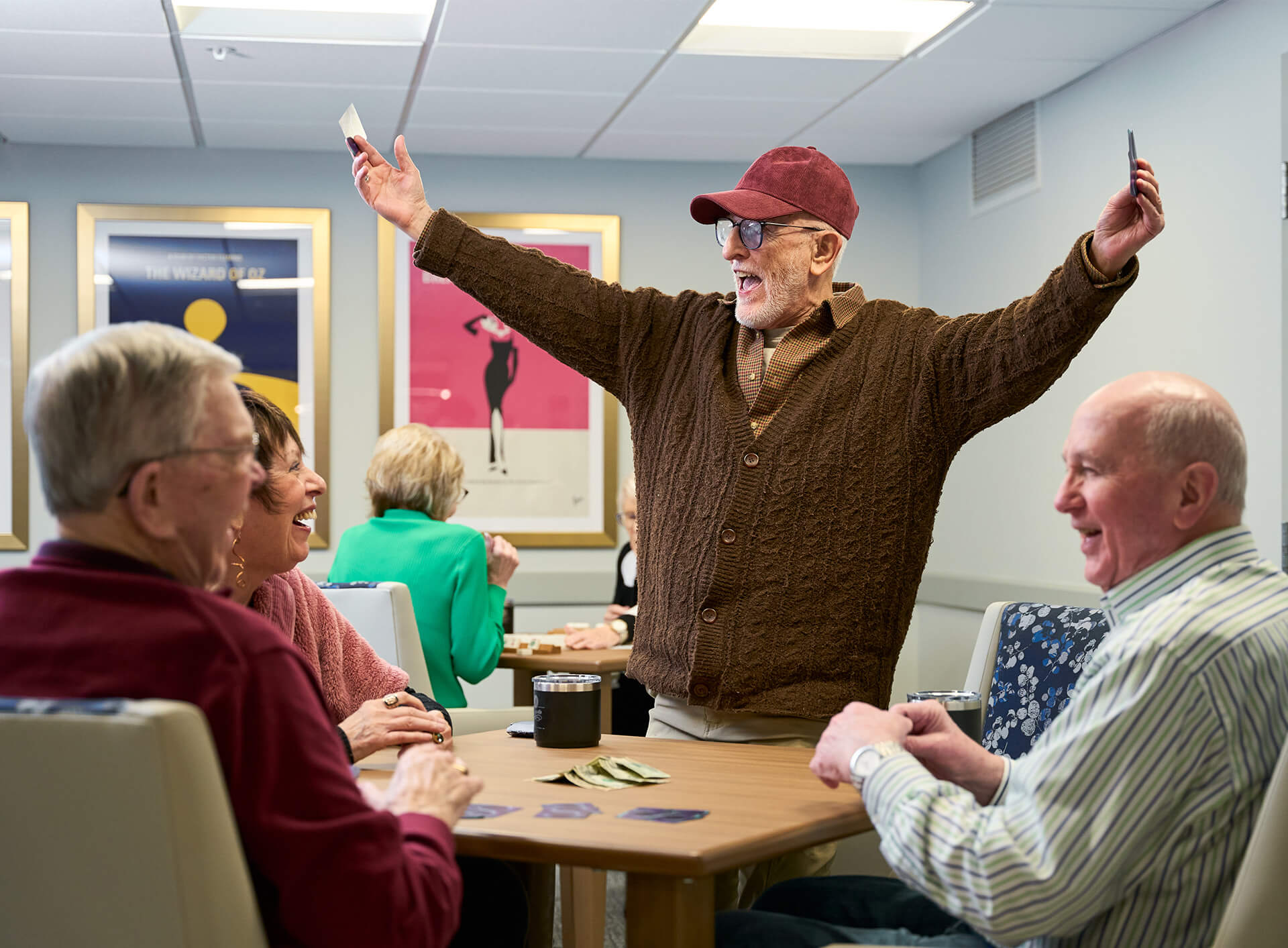 Residents enjoying a lively card game in a communal space at a senior living community.