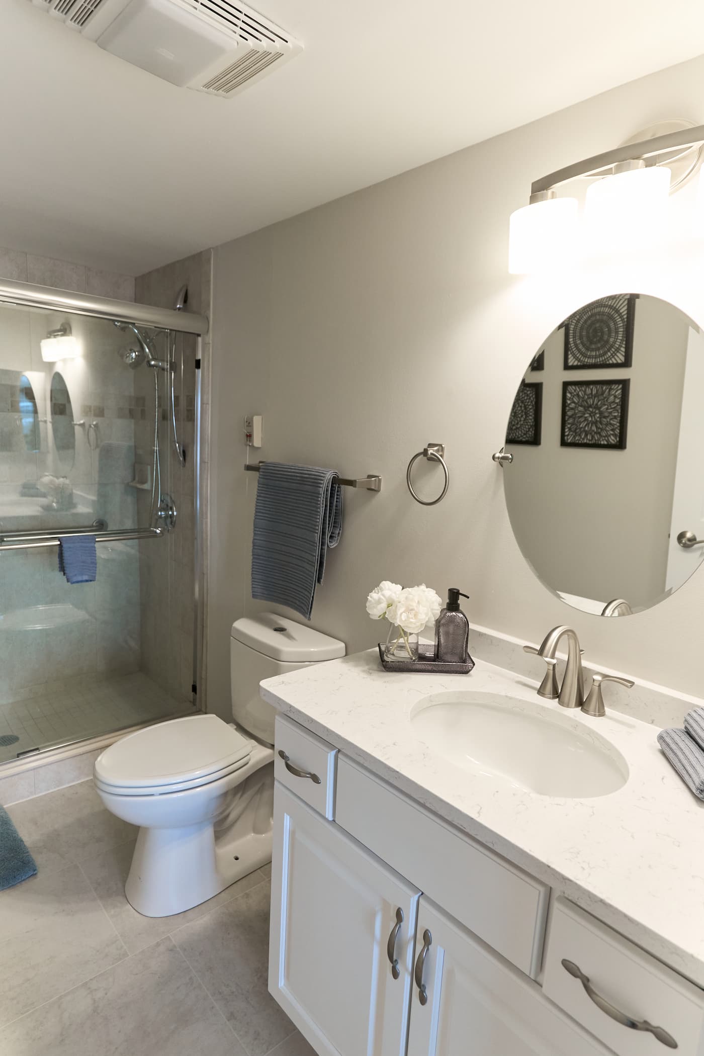 Modern bathroom with glass shower, sink, and toilet in a senior living unit.