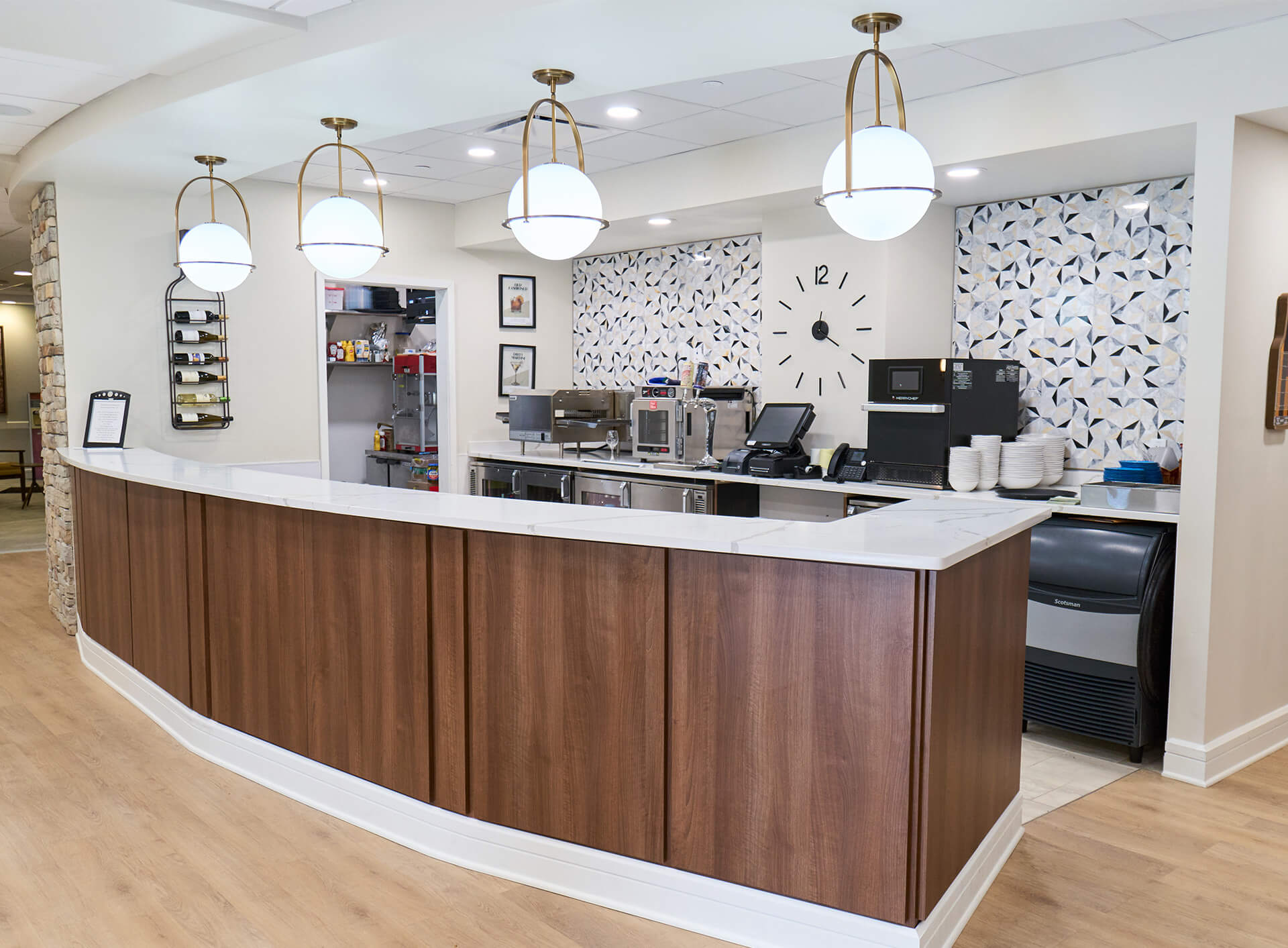 Modern counter area in a senior living community with elegant lighting and wood finish.