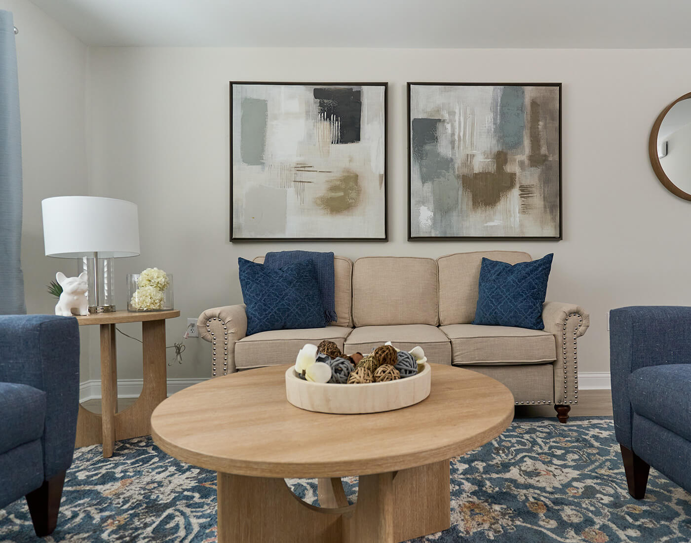 Cozy living area with a beige sofa, abstract art, and wooden furniture.