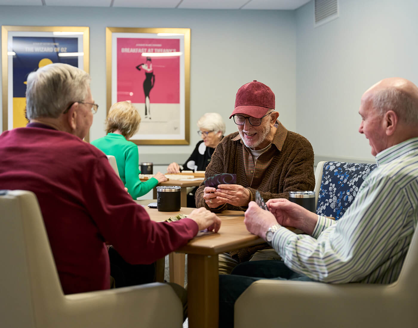 Residents playing cards at a senior community, enjoying leisure time together.