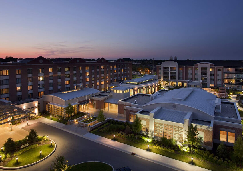 Aerial view of a senior living community at dusk with lights illuminating the buildings.