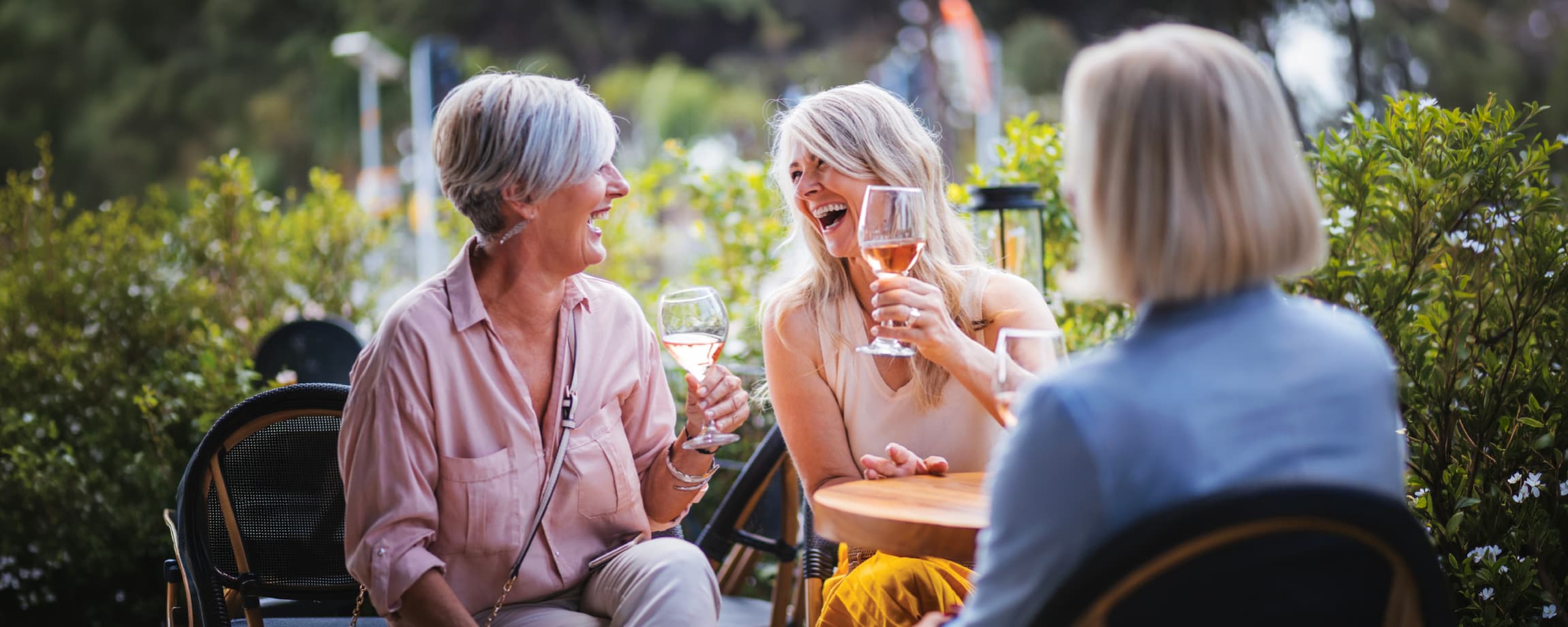 Three senior women drinking wine and laughing